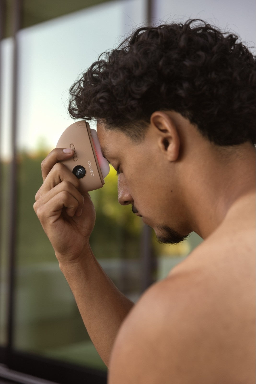 Man using Cosmo Health electric cupping device on his forehead, relieving tension and promoting lymphatic drainage, muscle recovery, and improved circulation. Outdoor wellness routine with Cosmo Health’s electric cupping device for pain relief and enhanced mobility.